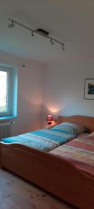 ein Schlafzimmer mit einem Bett, einer Lampe und einem Fenster in der Unterkunft Ferienwohnung Gieske - Wollmann in Westerholz