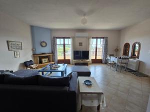 a living room with a couch and a table at Booklou Apartment in Ancient Epidauros