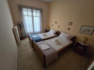 a bedroom with two beds and a window at Booklou Apartment in Ancient Epidavros