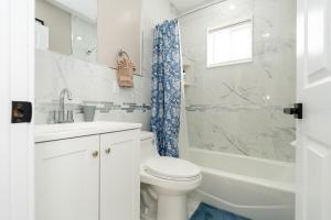 a white bathroom with a toilet and a shower at 558-3 3BR Boston - Modern Nest near Franklin Park in Boston +39 photos