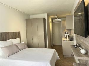 a bedroom with a white bed and a kitchen at One Rosebank in Johannesburg
