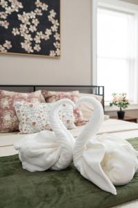 two white swans sitting on top of a bed at 558-3 3BR Boston - Modern Nest near Franklin Park in Boston