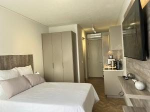 a bedroom with a white bed and a kitchen at One Rosebank in Johannesburg +11 photos