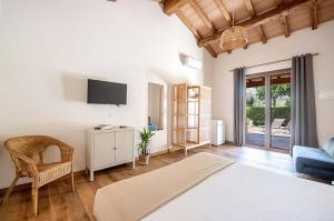 a bedroom with a bed and a couch and a tv at Agriturismo La Sassicaia in Castiglione della Pescaia
