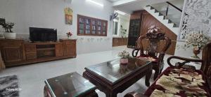 a living room with a coffee table and a tv at Chi's House in Hue