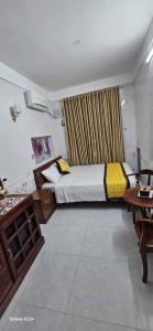 a bedroom with a bed and a table in a room at Chi's House in Hue