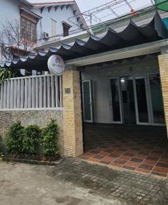 a house with a white fence and a sign on it at Chi's House in Hue