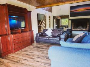 Una sala de estar con sofás y un televisor de pantalla plana. en 18 Kingfisher Gamtoos, en Gamtoosriviermond