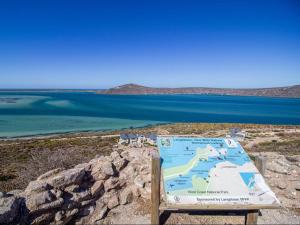 Un cartel en la cima de una colina junto al agua. en La Vie & Plan D'eau, en Langebaan 5 fotos más