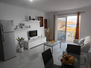 a living room with a refrigerator and a television at Ocean view Apartment 2 in Cidade Velha