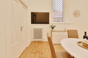 a white dining room with a table and a window at Casa di borgo in Rome