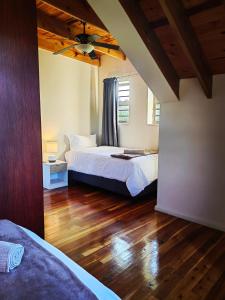 Un dormitorio con dos camas y suelo de madera. en 18 Kingfisher Gamtoos, en Gamtoosriviermond