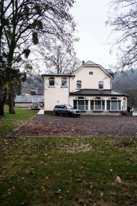 a car parked in front of a white house at Maison Meuse in Waulsort