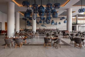 a dining room with tables and chairs and chandeliers at Royal Villas Resort in Mazatlán