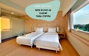 Ένα ή περισσότερα κρεβάτια σε δωμάτιο στο Whiz Prime Hotel Sudirman Cilacap