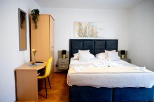 a bedroom with a large bed with a table and a chair at Apartmani Nil in Barić Draga
