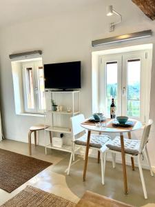 a dining room with a table and chairs and a tv at Loft in Panzano in Panzano