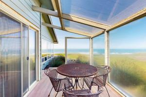 un patio con tavolo e sedie su un balcone di Misty Rose a Fort Bragg