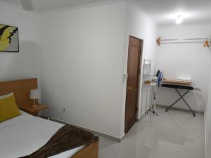 ein Schlafzimmer mit einem Bett und einem Schreibtisch darin in der Unterkunft Catedral View Apartment in Cidade Velha