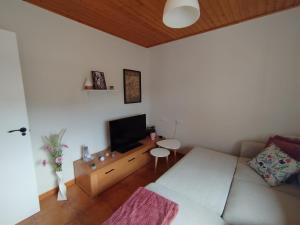 a living room with a couch and a flat screen tv at A Casiña de Rande in Redondela +25 photos