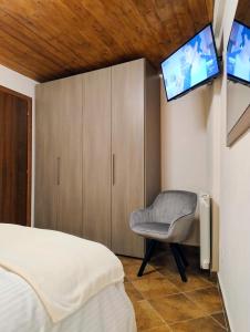 a bedroom with a bed and a chair with two televisions at Dimoramica LTB in Foligno
