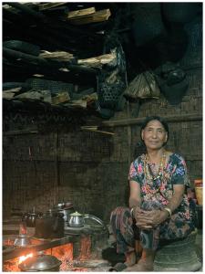 a woman sitting in a room with pots and pans at Longsha homestay in Mon