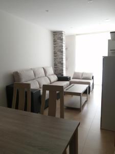 a living room with a couch and a table at Apartamentos Rompeolas in Burela de Cabo