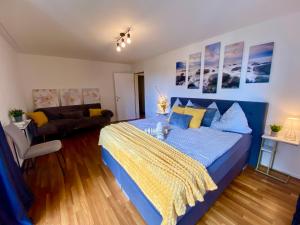 a bedroom with a blue bed and a couch at City Views Apartment am Schaffhauserplatz in Zürich