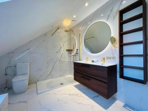 Un baño con lavabo, espejo e inodoro. en Maison Jacqueline, en Nieuwpoort 57 fotos más