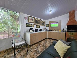 a living room with a couch and a tv in it at Quartos em Sítio para Agrishow, RRM e João Rock in Ribeirão Preto +18 photos