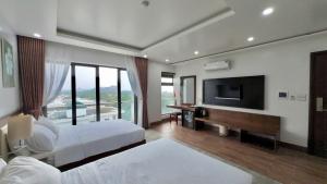 a hotel room with two beds and a flat screen tv at Hệ thống Khách Sạn Sen Biển - FLC Sầm Sơn in Sầm Sơn