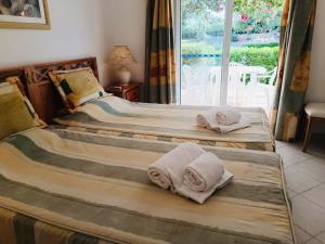 two beds with towels on them in a bedroom at Balaia Golf Village T2 a 10 minutos da praia in Olhos de Água +20 photos