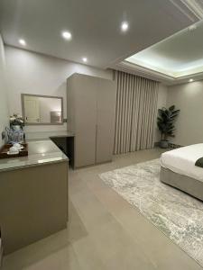 een slaapkamer met een bed en een bureau met een spiegel bij Alarjan Dream in Riyad
