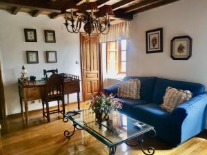 a living room with a blue couch and a piano at O Chanto in Cedeira