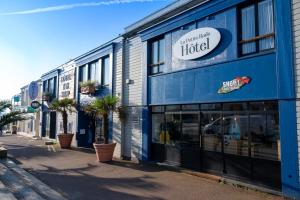a blue building with a hotel on a street at LOGIS HOTEL - La Petite Rade in Le Havre