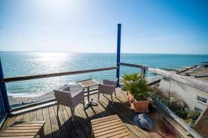 a balcony with a table and chairs and the ocean at LOGIS HOTEL - La Petite Rade in Le Havre