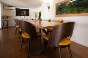 a dining room with a wooden table and chairs at LOGIS HOTEL - La Petite Rade in Le Havre