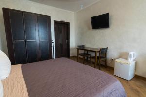a bedroom with a bed and a table and a television at Шахерезада in Vinnytsya