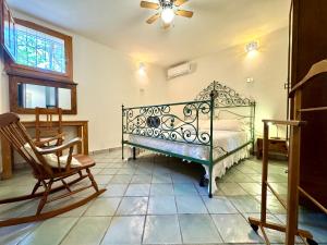a bedroom with a bed and a chair and a window at Colori di Sardegna Apartments in Bari Sardo
