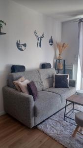 een woonkamer met een bank en een tafel bij La parenthèse du lac in Gérardmer