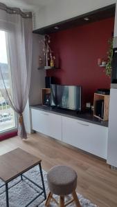 a living room with a tv on a counter at La parenthèse du lac in Gérardmer