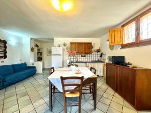 a kitchen and living room with a table and a blue couch at Colori di Sardegna Apartments in Bari Sardo +81 photos
