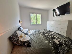 Sainte-Maxime appartement 45m avec jardin de 35m في سانت ماكسيم: غرفة نوم بسرير ومخدات وتلفزيون