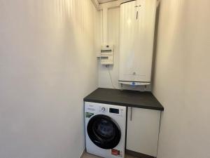 Sainte-Maxime appartement 45m avec jardin de 35m في سانت ماكسيم: غسالة ومجفف في زاوية من الغرفة