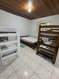 a room with two bunk beds and a tiled floor at Sítio do Zui SP in Piracaia