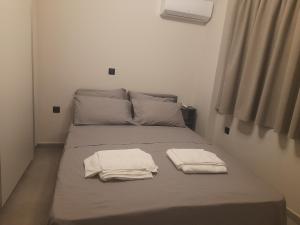 a bed with two towels sitting on top of it at Maisonette in Marousi in Athens
