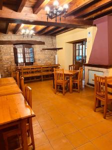 a dining room with wooden tables and wooden chairs at Albergue Pinares - La Casona de Revenga in Regumiel de la Sierra