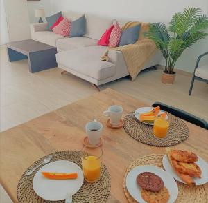 a living room with a table with plates of food at Sunset Bastián, junto a la costa in Costa Teguise
