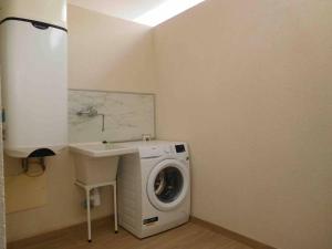 a bathroom with a washing machine and a sink at Sunset Bastián, junto a la costa in Costa Teguise