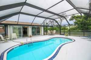 an outdoor swimming pool with a glass roof at Relaxing pool home in Englewood - Awake Zone in Englewood